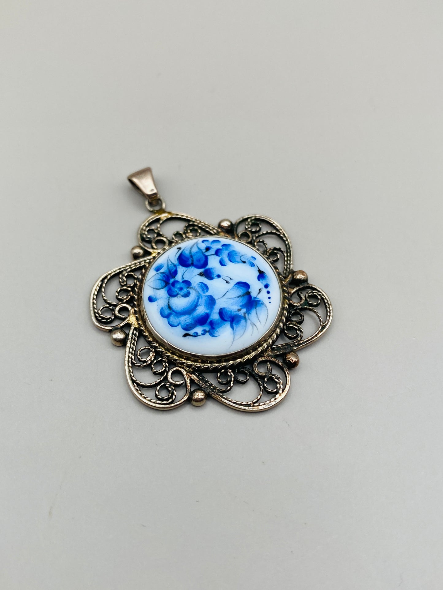 Pendentif vintage à décor floral bleu sur fond blanc – monture métal ajourée