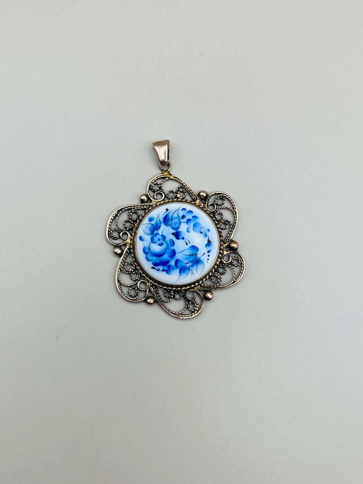 Pendentif vintage à décor floral bleu sur fond blanc – monture métal ajourée